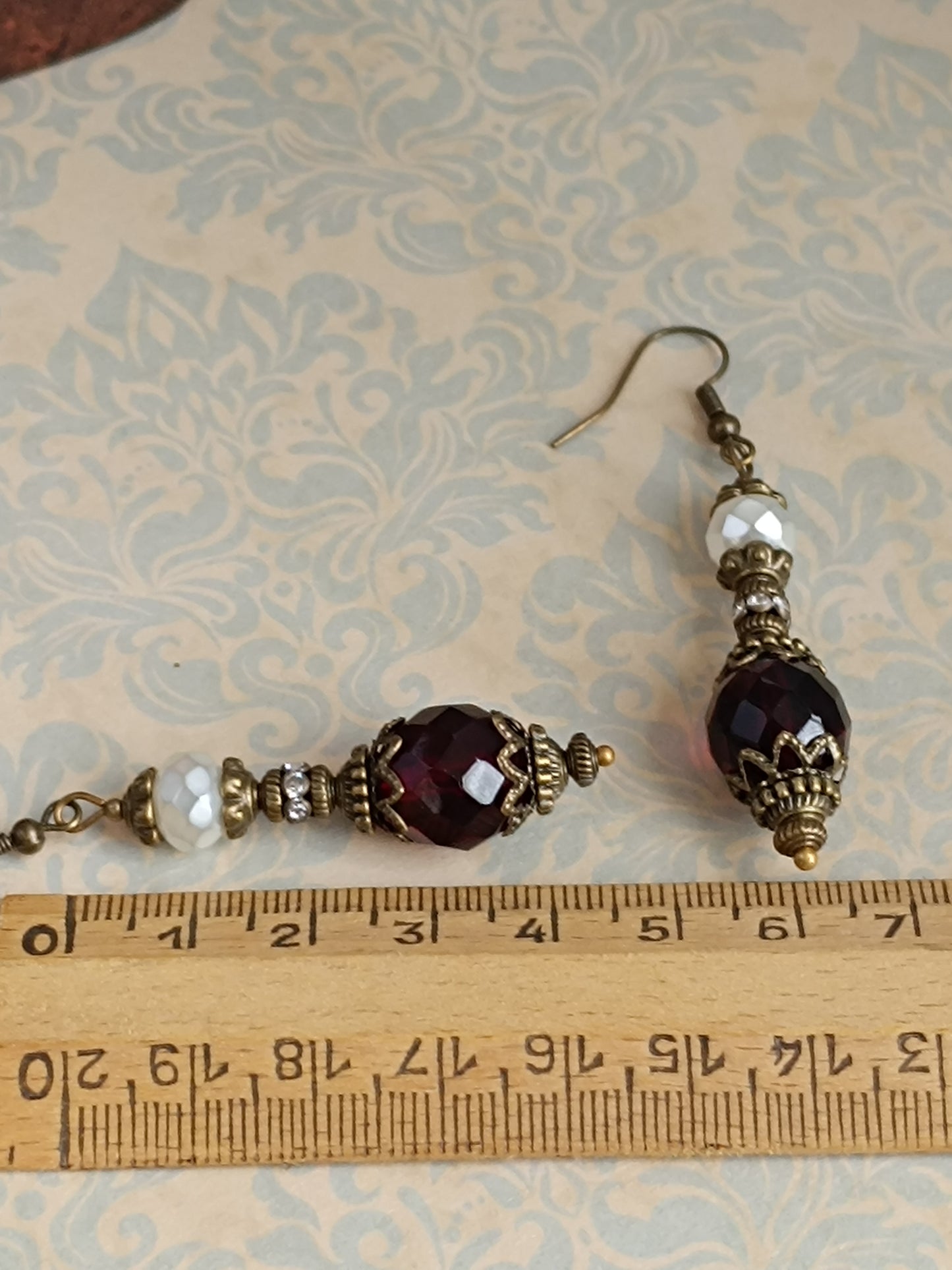 Boucles d'oreilles pendantes artisanales – Perles facettées rouges et blanches, métal bronze antique filigrané
