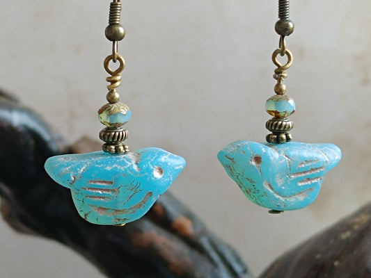 Boucles d'oreilles pendantes oiseaux en verre tchèque turquoise patiné, perles facettées et montage laiton bronze antique, style bohème folk nature — bijou artisanal Aucoudesanges