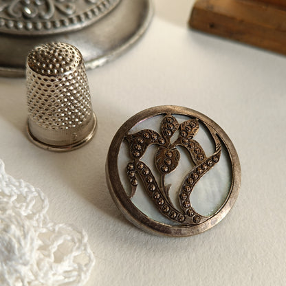 Broche unique créée à partir d’un bouton français en nacre et bronze texturé des années 1930, au motif d’iris. Pièce collector transformée avec soin, alliant élégance vintage et modernité. Diamètre 3 cm. Livrée dans une boîte vintage.