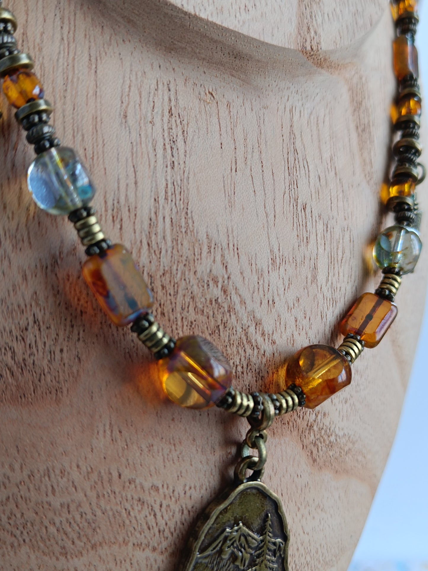 Collier câblé – Perles heishi, verre tchèque et bronze – Pendentif montagnes sauvages avec ours et pointes de flèche
