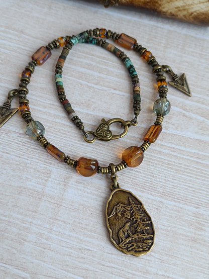 Collier câblé – Perles heishi, verre tchèque et bronze – Pendentif montagnes sauvages avec ours et pointes de flèche
