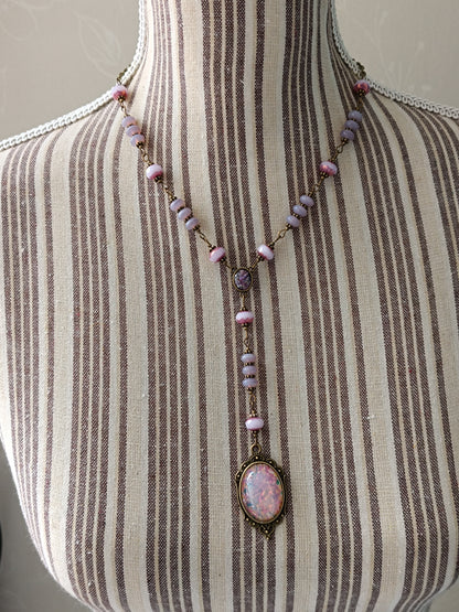 Détail du connecteur de collier vintage : petit cabochon en verre Silver Foil violet, perles opaline roses et laiton antique.