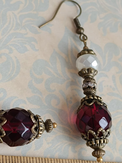 Boucles d'oreilles pendantes artisanales – Perles facettées rouges et blanches, métal bronze antique filigrané
