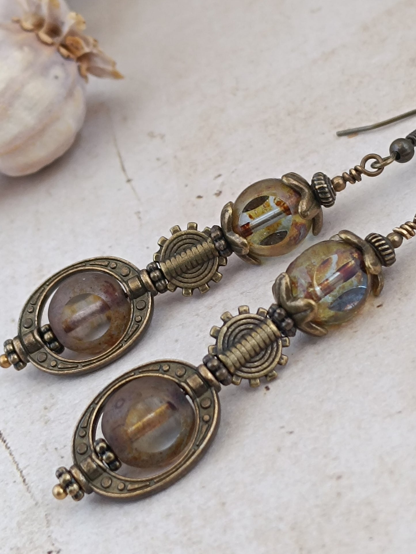 Boucles d'oreilles steampunk posées sur bois, perles 3 coupes verre tchèque irisées et monture ovale engrenage bronze antique