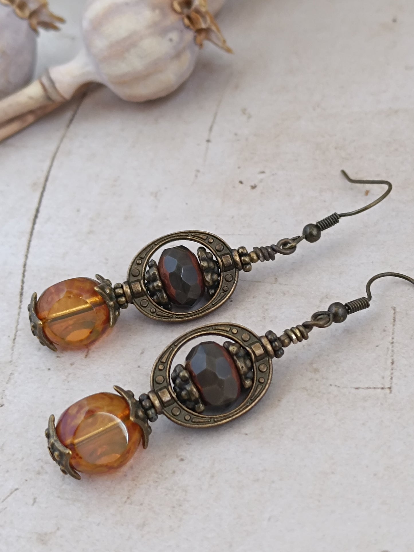 Boucles d'oreilles pendantes Dark Academia verre tchèque brun grenat et perle 3 coupes ambrée, monture bronze antique, fond bois blanc