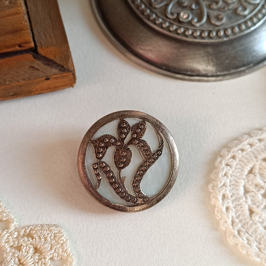 Découvrez cette broche confectionnée à partir d'un bouton de nacre français des années 1930. Métal texturé bronze, diamètre 3 cm. Accessoire élégant et rare par Nathalie Aucoudesanges.