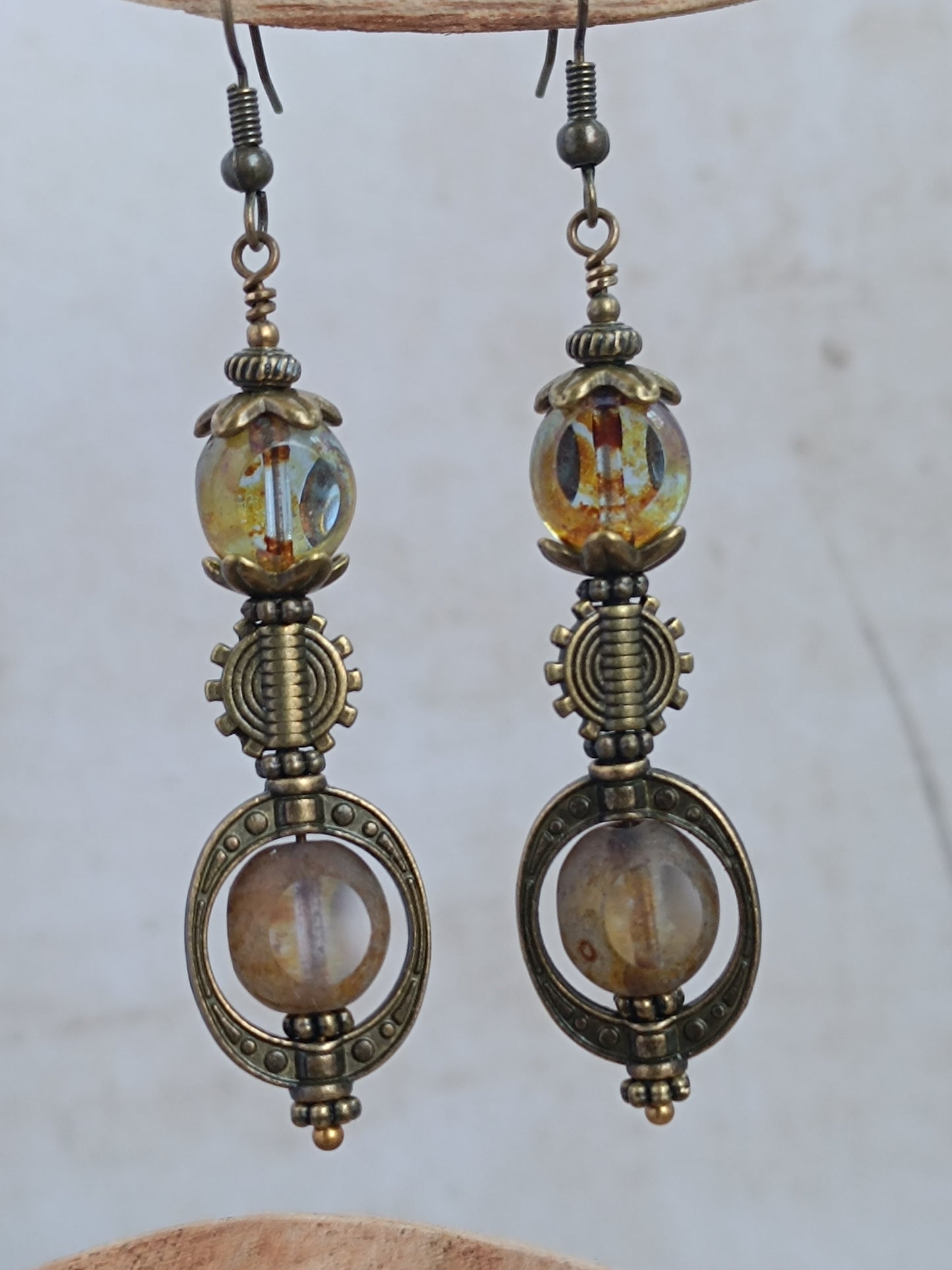 Boucles d'oreilles pendantes steampunk sur présentoir bois, perles 3 coupes verre tchèque finition Picasso et engrenage bronze antique