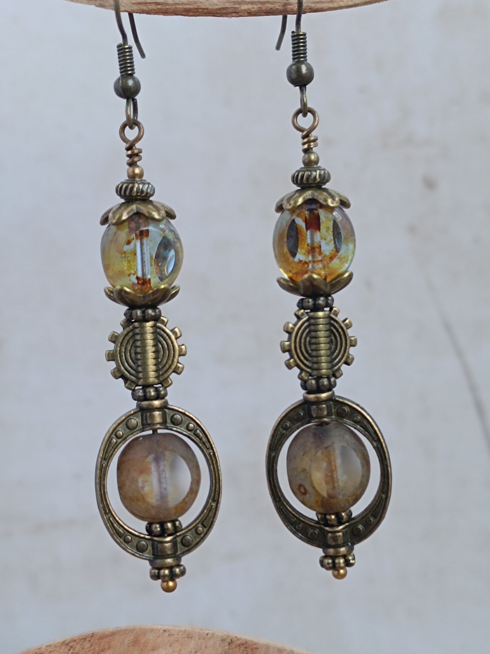 Boucles d'oreilles pendantes steampunk sur présentoir bois, perles 3 coupes verre tchèque finition Picasso et engrenage bronze antique