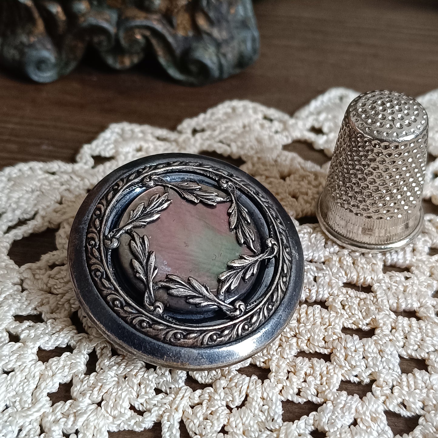 Broche vintage en nacre irisée avec couronne de laurier en métal bronze, créée à partir d’un bouton français des années 1930 gravé Paris. 