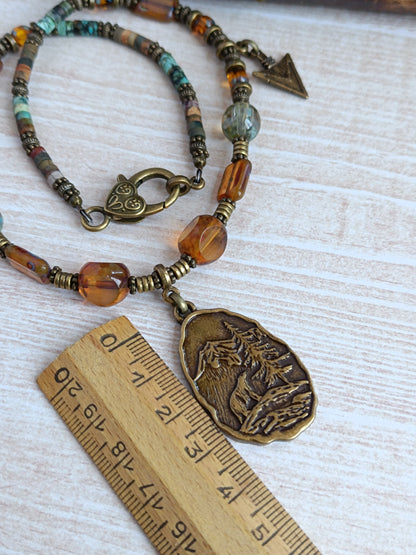 Collier câblé – Perles heishi, verre tchèque et bronze – Pendentif montagnes sauvages avec ours et pointes de flèche