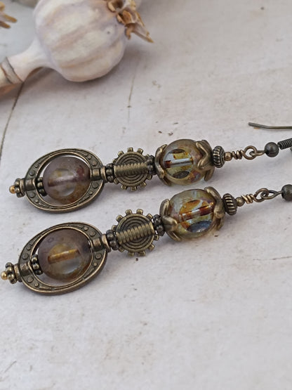 Boucles d'oreilles steampunk néo-victoriennes, perles 3 coupes verre tchèque et monture ovale bronze antique, fond bois blanc